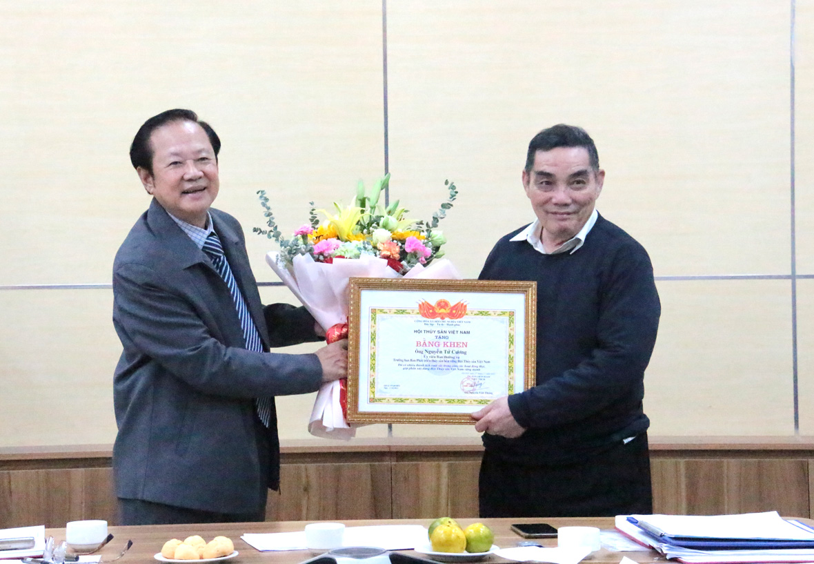 Ông Nguyễn Việt Thắng (bên trái ảnh) trao bằng khen tặng ông Nguyễn Tử Cương vì có những đóng góp tích cực cho sự phát triển của Hội.